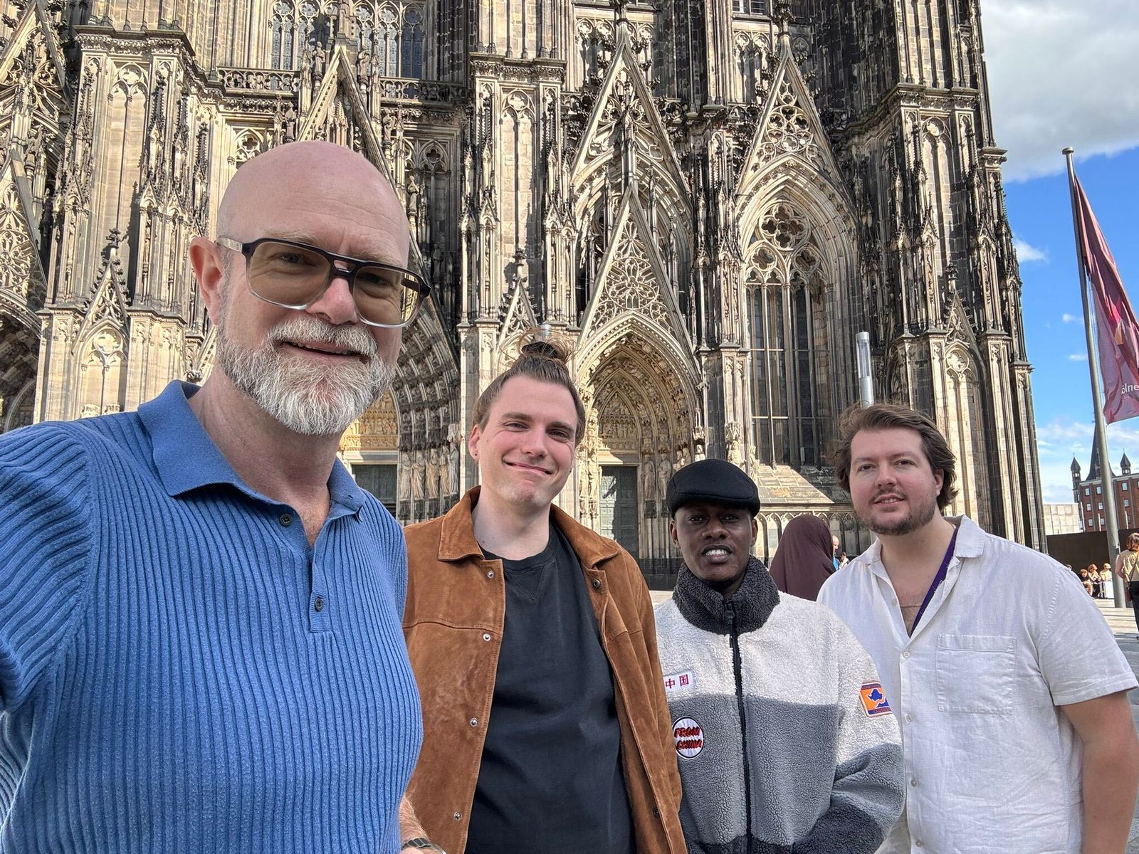 A selfie of Michael and colleagues outside Cologne Cathedral on a sunny day