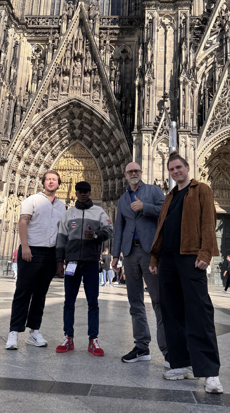 Michael Wambua Nzisa with three colleagues in front of Cologne Cathedral